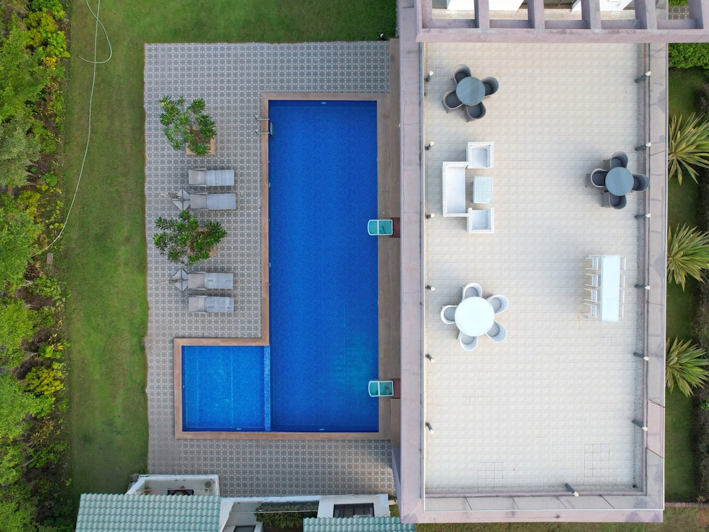 An aerial view of a landscaped pool and patio area